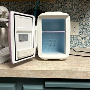 Cooluli skin care fridge in light purple, hot and cold settings.